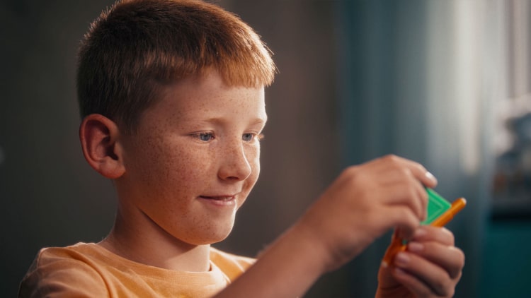 a boy playing with a magnetic toy